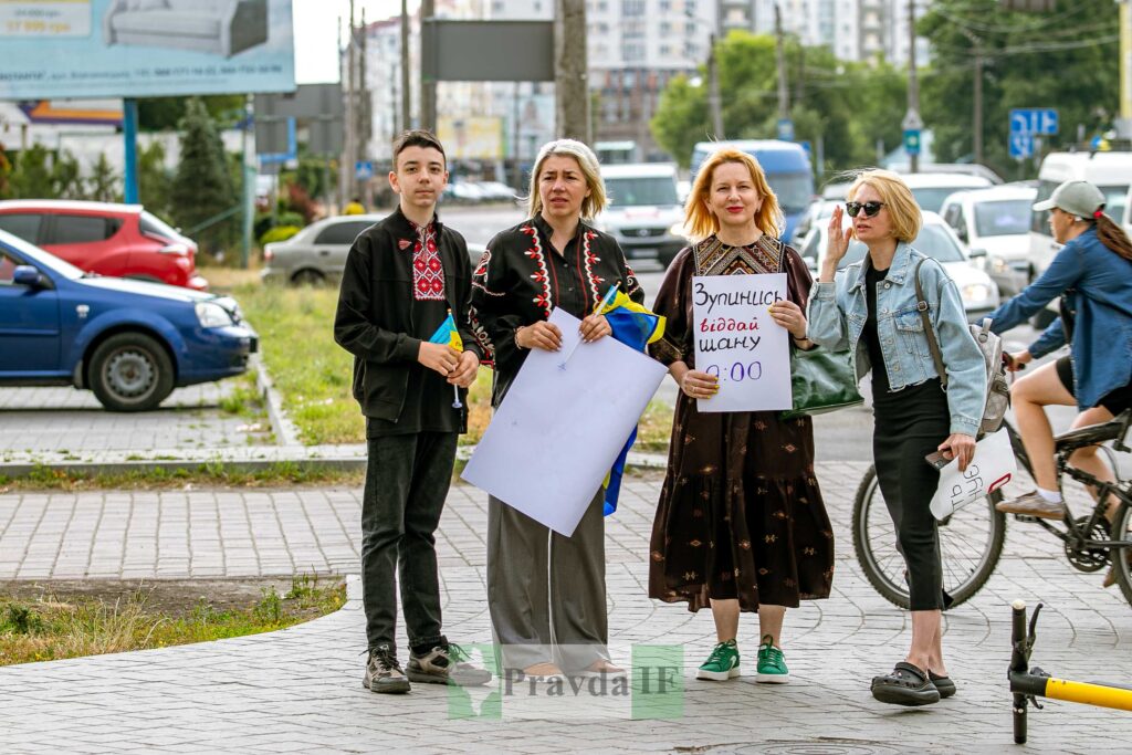Люди з плакатами на вулиці в Україні.