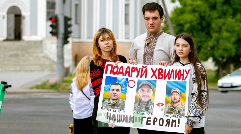 Молодь з плакатом в честь героїв України.