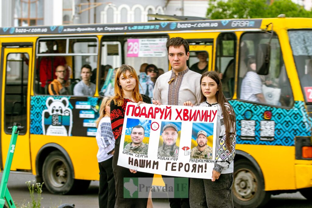 Люди з плакатом для збору допомоги героям