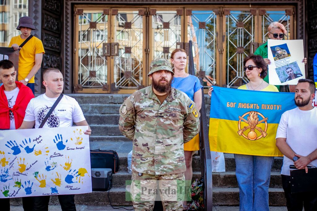 Люди з українськими прапорами на протесті