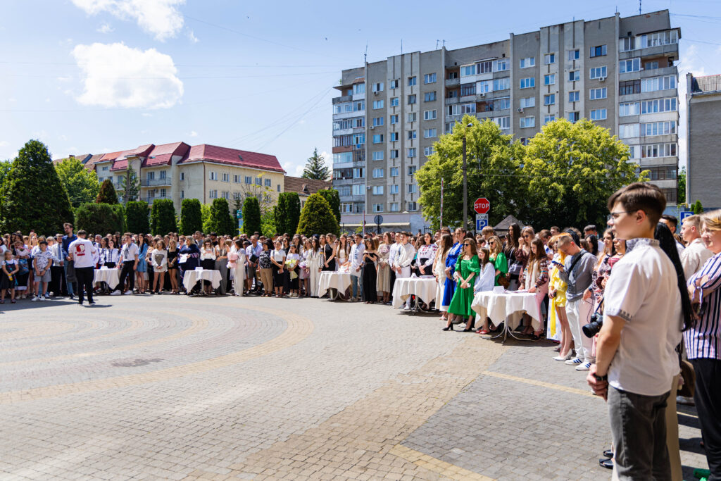 Шкільна церемонія на подвір'ї, учні та гості.