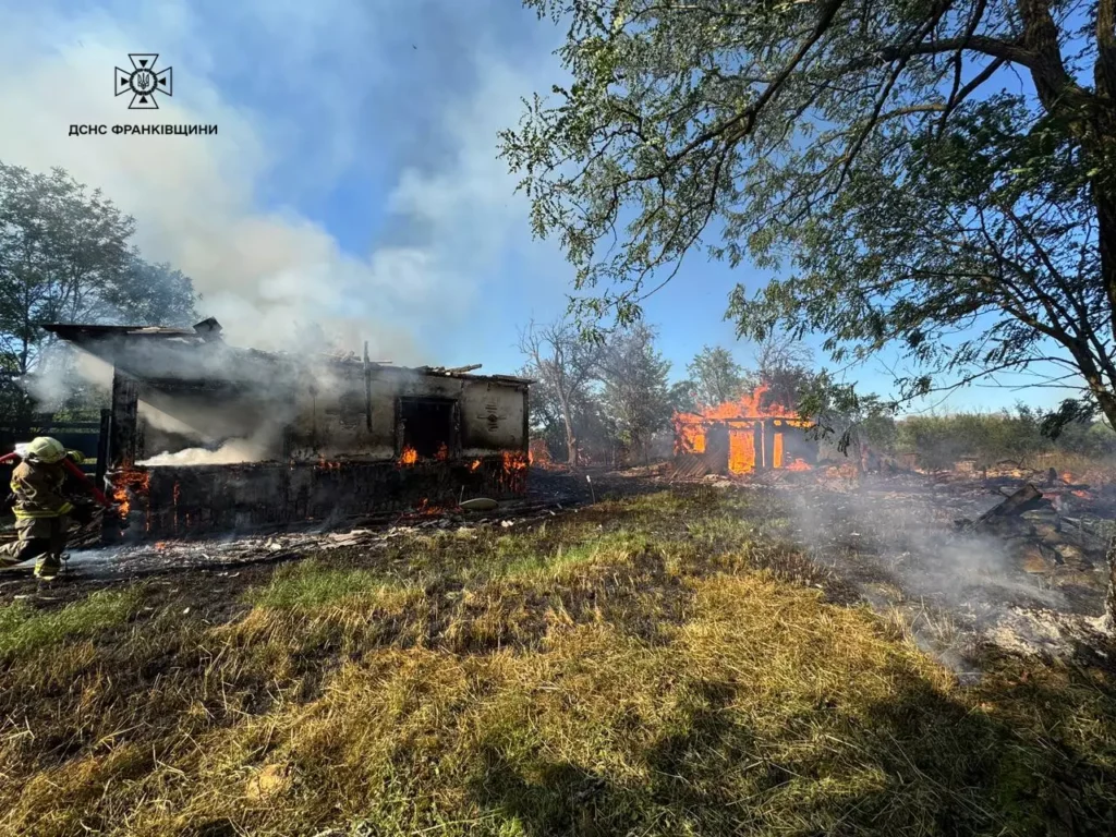 Будинок у вогні, пожежник бореться з пожежею.