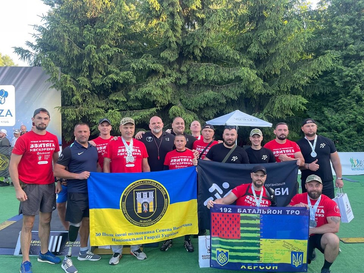 Група військових з прапорами на змаганнях в Україні.