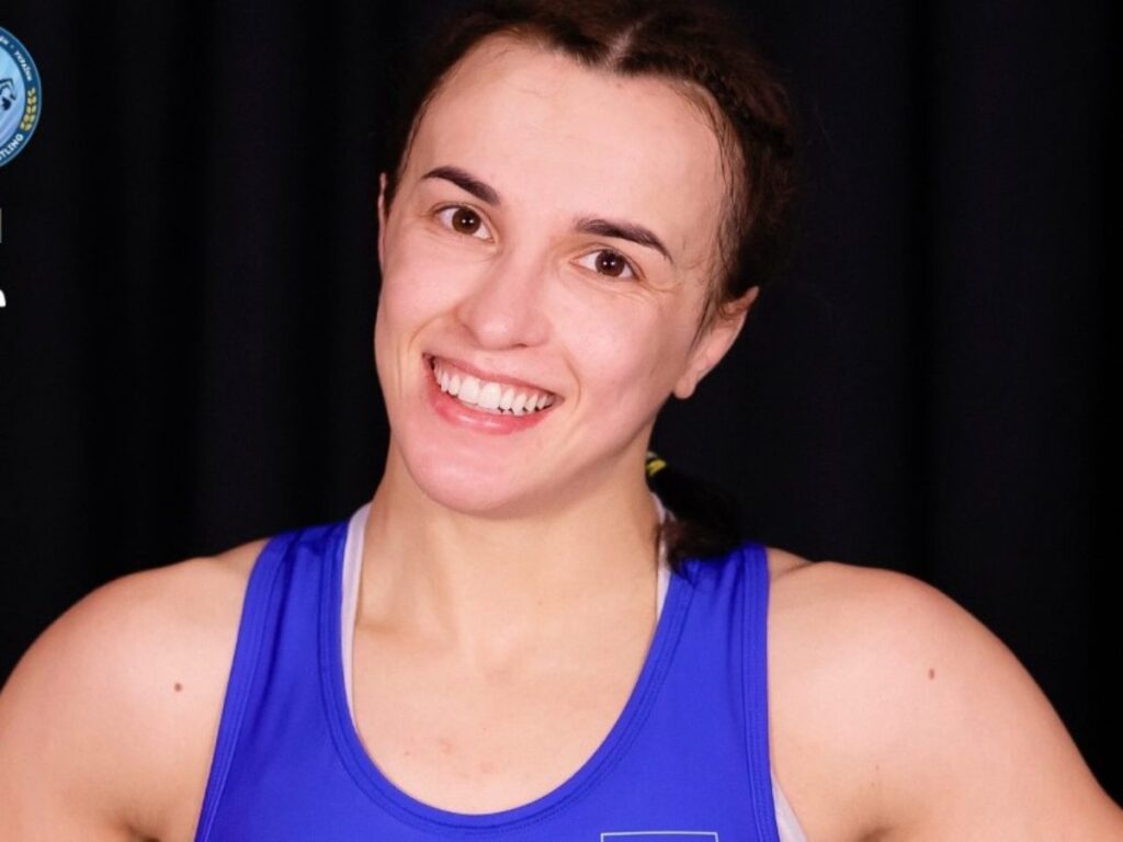 Усміхнена жінка в синьому спортивному одязі.