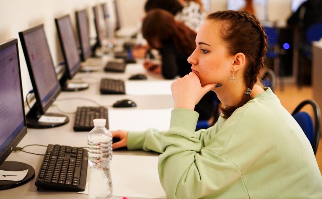 Студентка працює за комп'ютером у класі