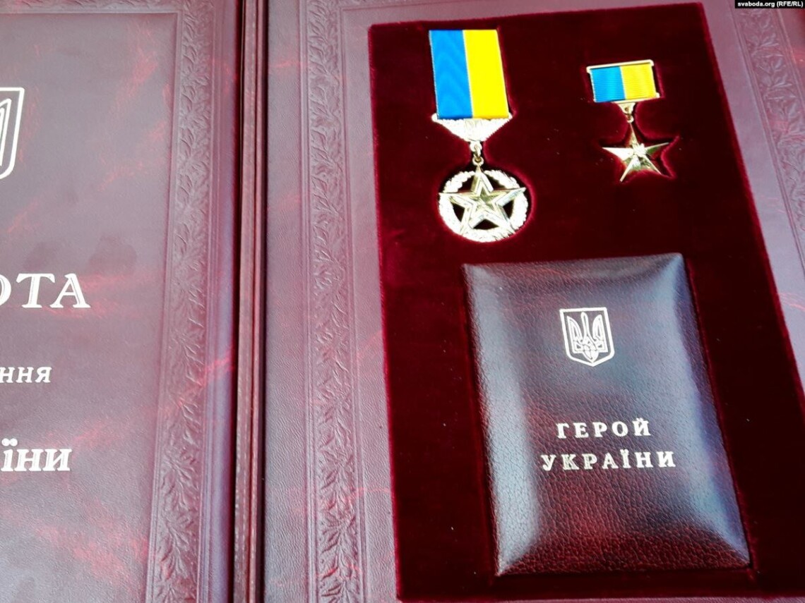 Нагороди Героя України на червоній підкладці.