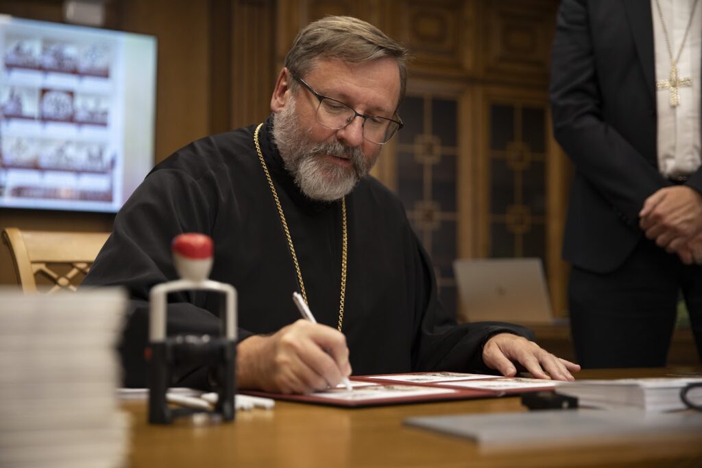 Священик підписує документи у кабінеті
