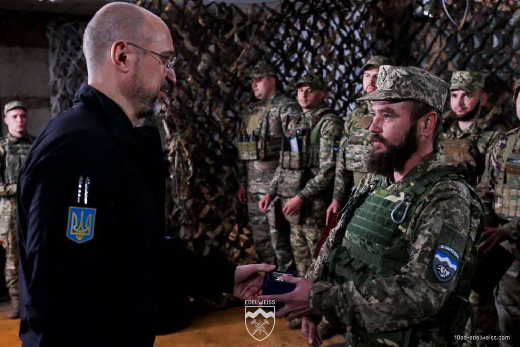 Вручення нагороди українському солдату у камуфляжі.