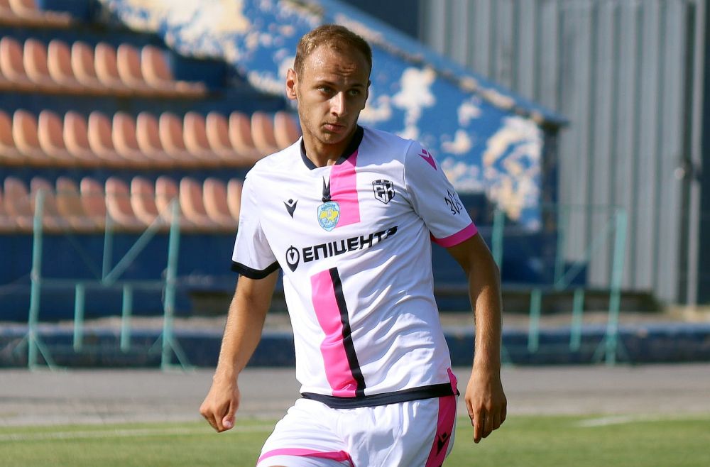 Футболіст у біло-рожевій формі на полі