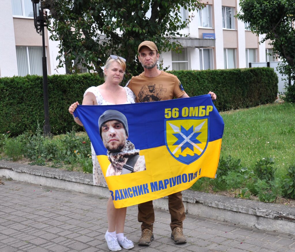 Люди з прапором 56-ї бригади на вулиці.