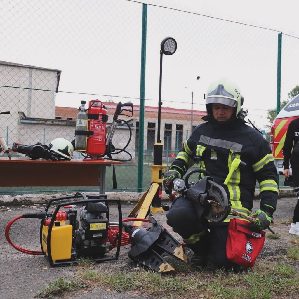 Пожежник перевіряє аварійне обладнання на відкритому повітрі.