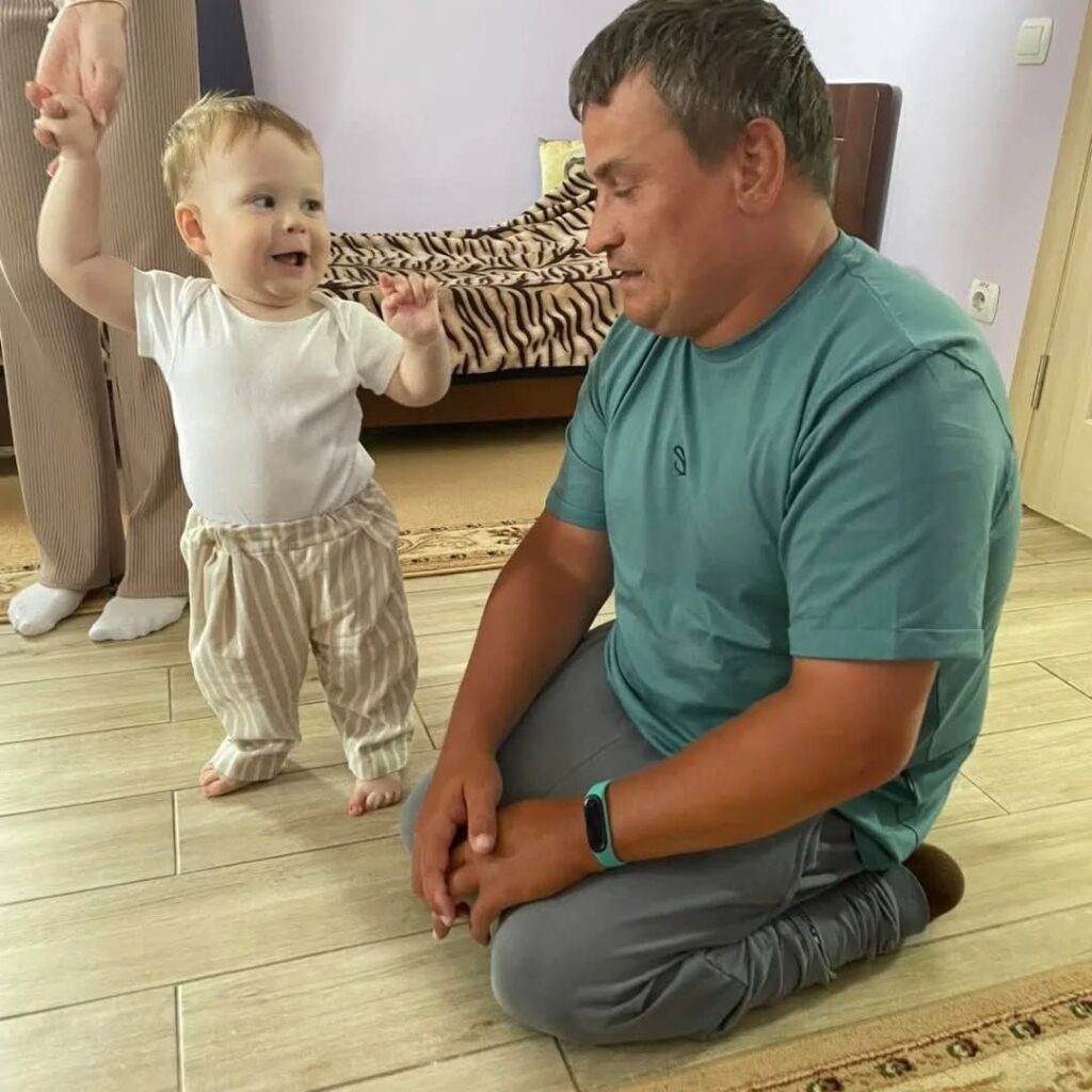 Радісна дитина з чоловіком на підлозі кімнати