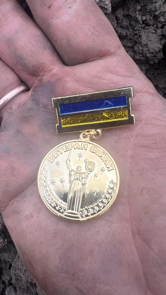 Медаль ветерана війни на брудній долоні