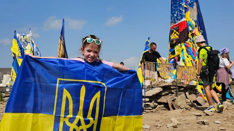 Дитина з прапором України на вершині гори