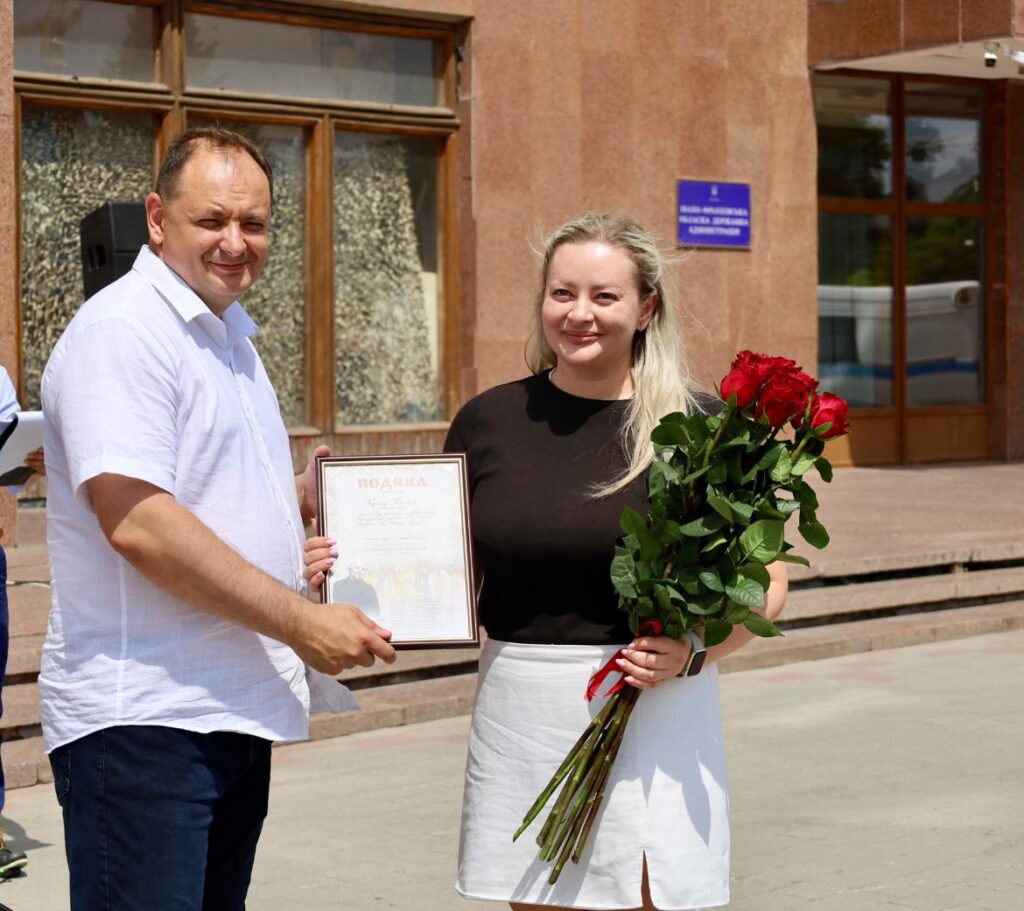 Чоловік вручає жінці подяку й квіти