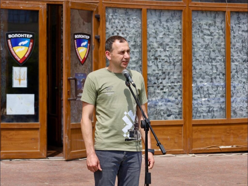 Чоловік виступає на вулиці біля входу.