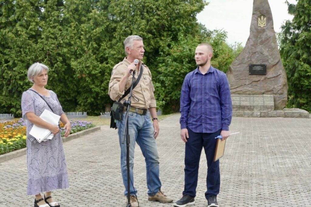 Люди поруч з пам'ятником на відкритому повітрі.