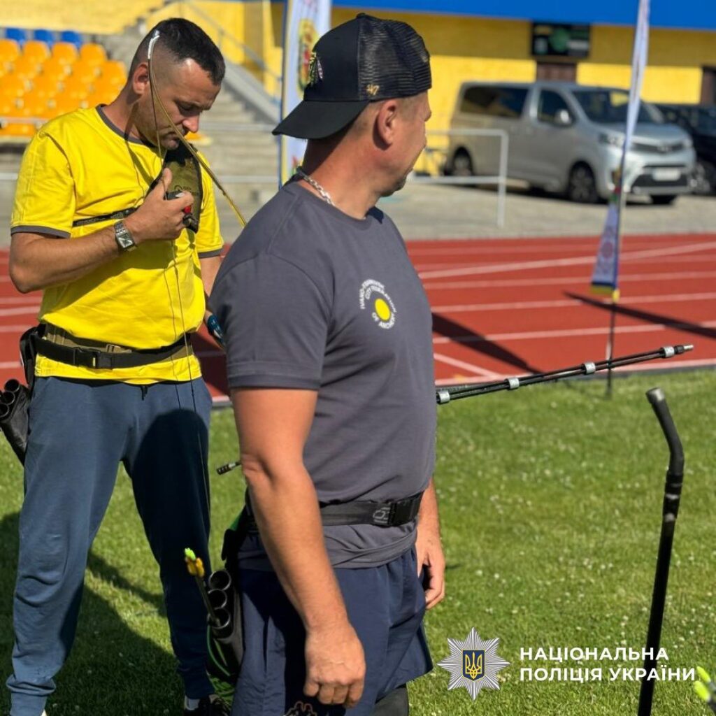 Двоє чоловіків з луками на спортивному полі.
