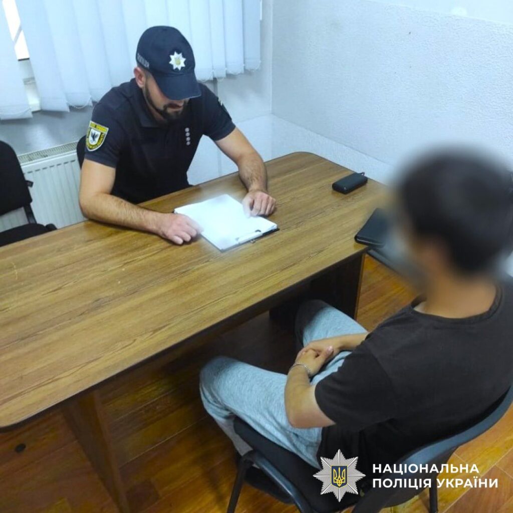 Поліцейський допитує особу в офісі.