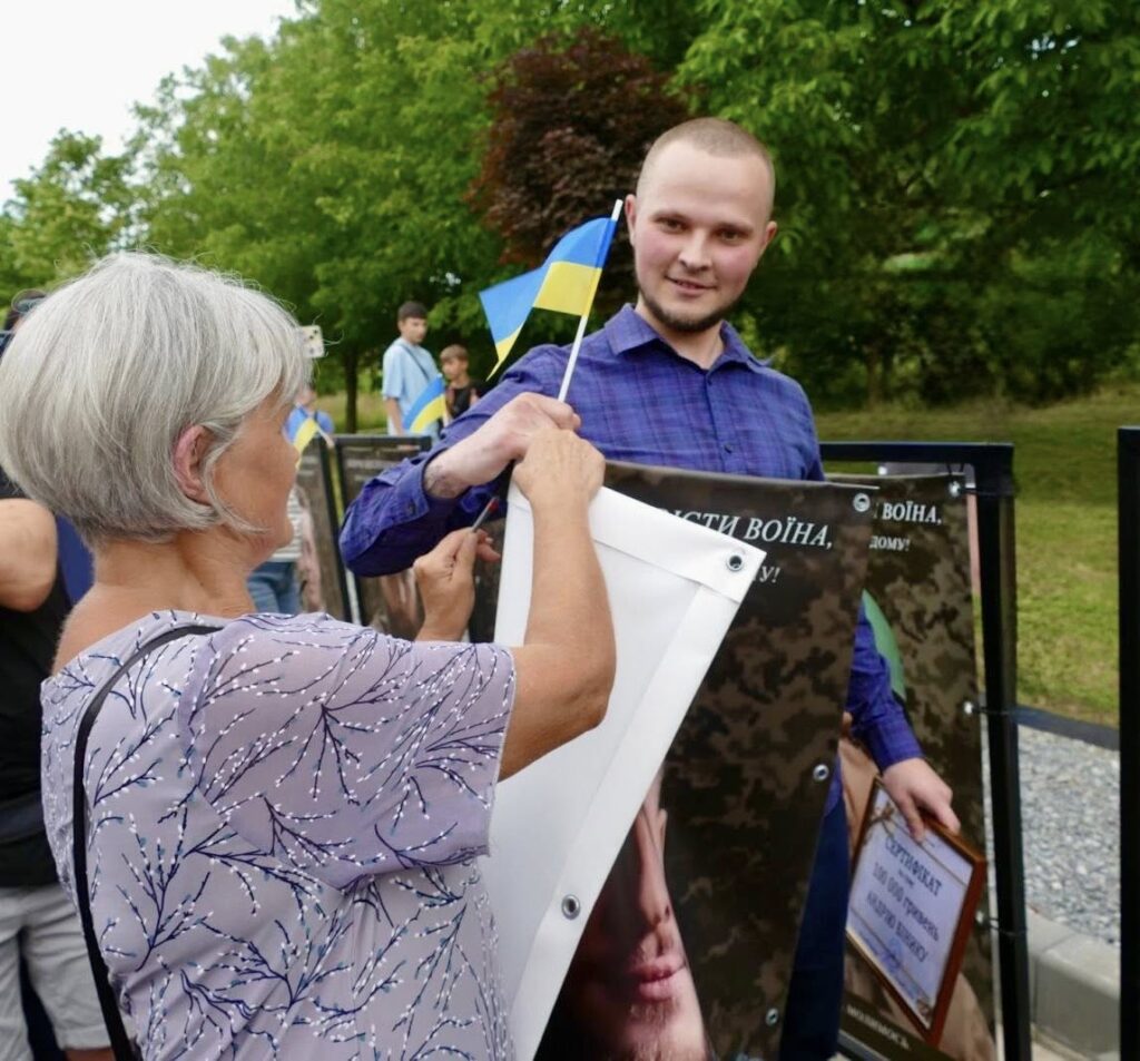 Люди з українськими прапорами на пікеті