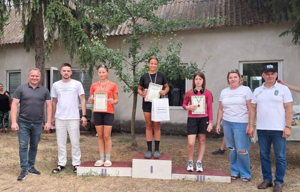 Три жінки з нагородами на пьєдесталі.