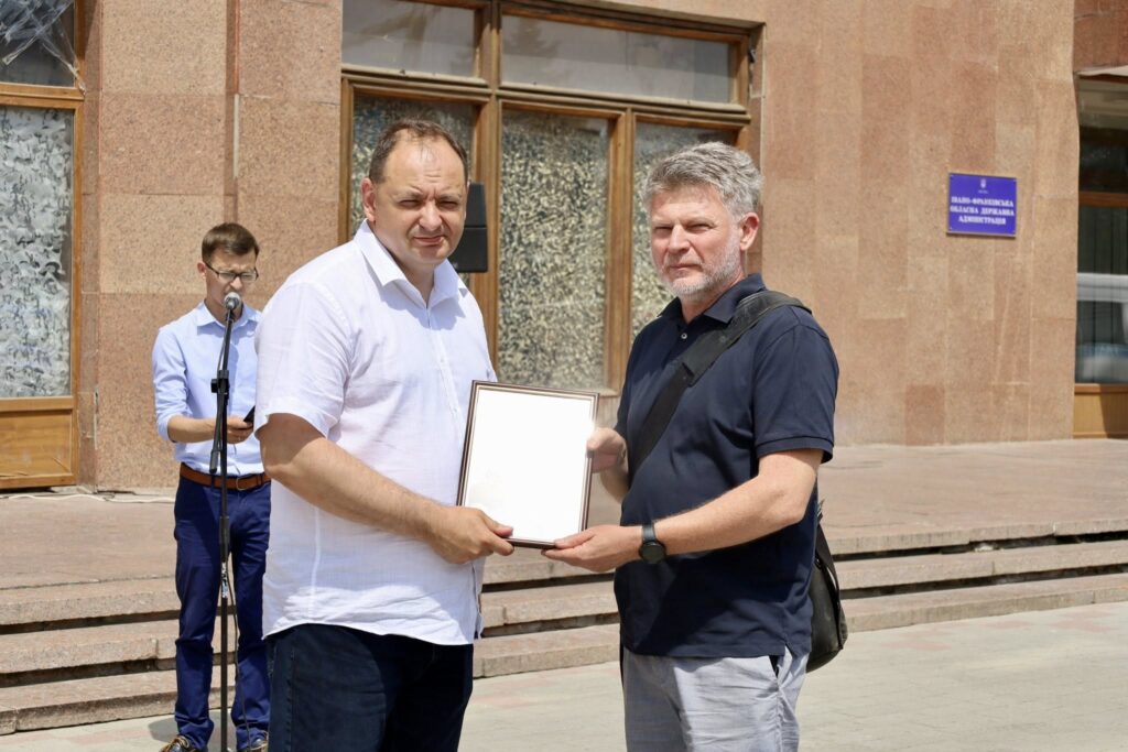 Вручення сертифіката перед будівлею адміністрації