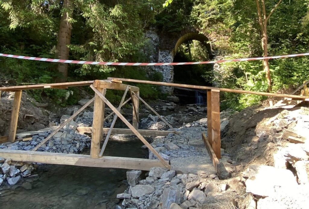 Будівництво дерев'яного моста біля лісу та арки.