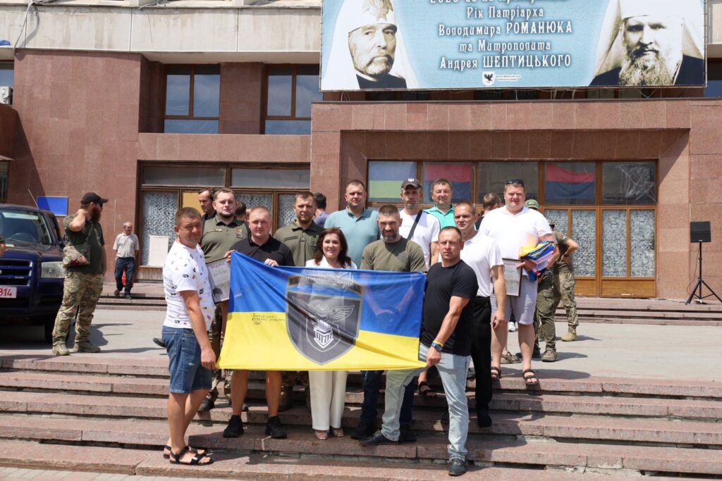 Група людей з українським прапором на сходах.
