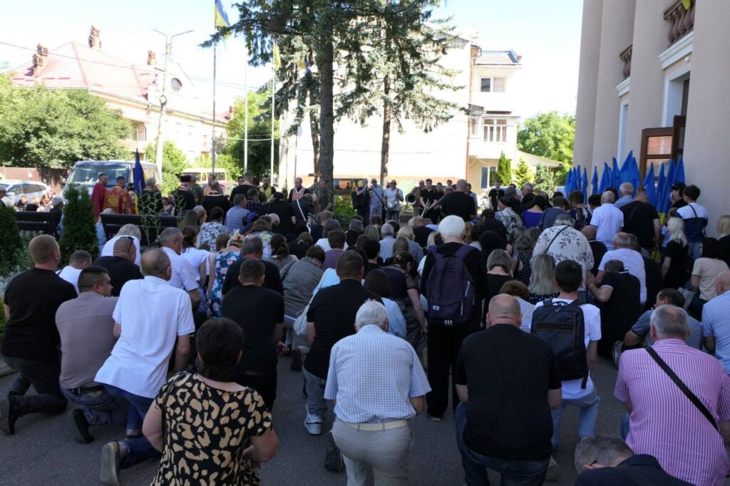 Люди на колінах під час заходу на вулиці.