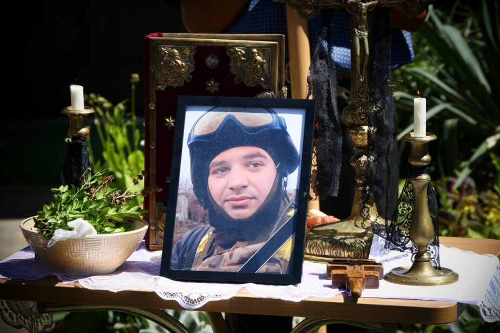 Портрет військового в меморіальній експозиції з свічками.