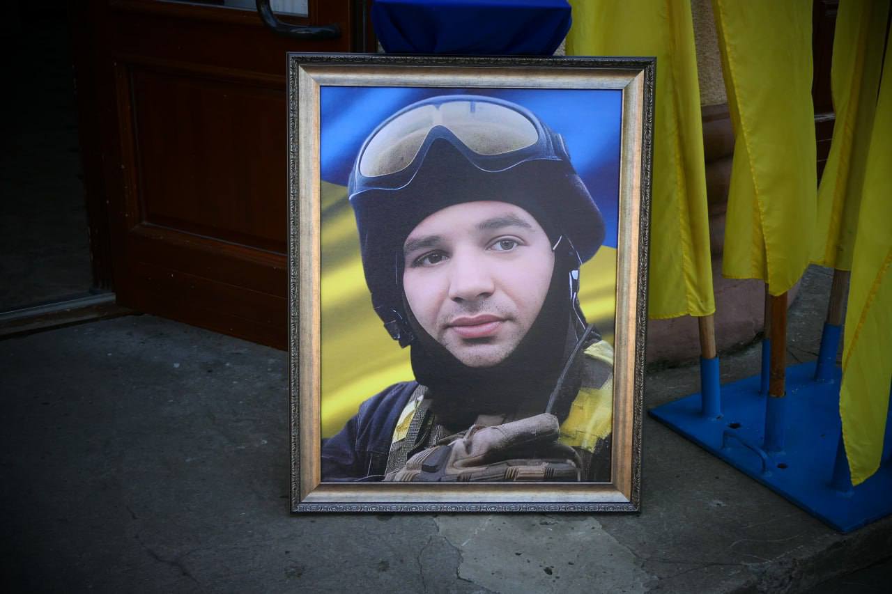 Портрет солдата на тлі українського прапора.