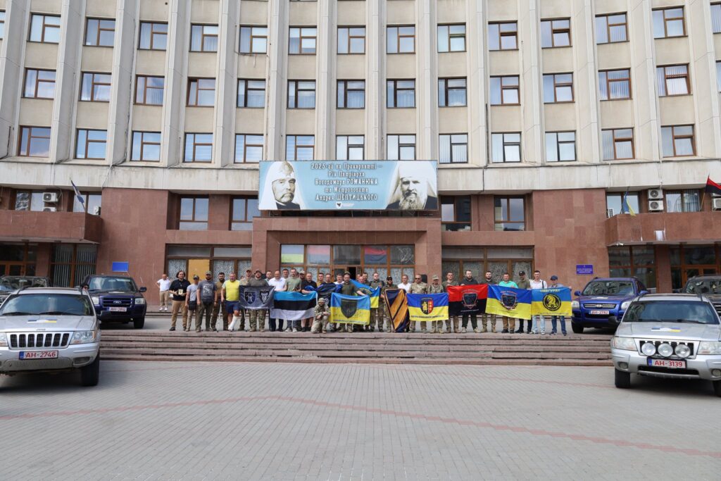 Група людей з прапорами перед будівлею