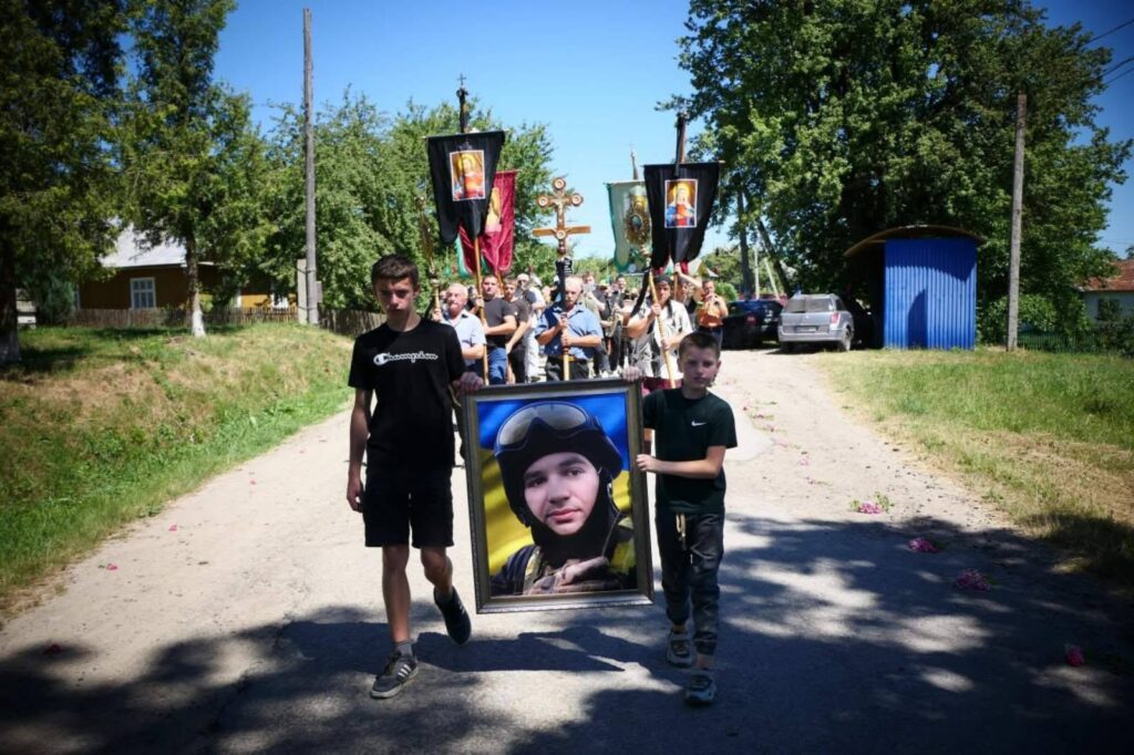 Процесія з портретом військового на вулиці.