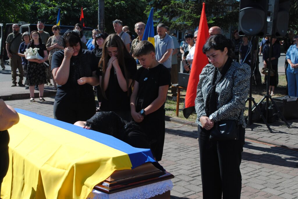 Прощання з труною, покритою українським прапором.