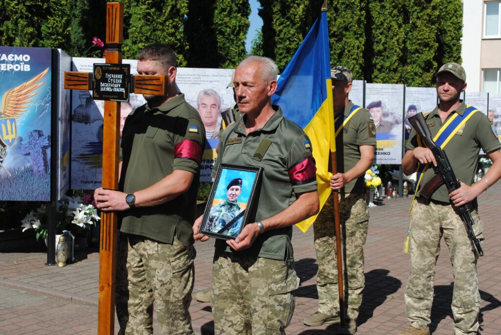 Військові на церемонії з прапором та портретом
