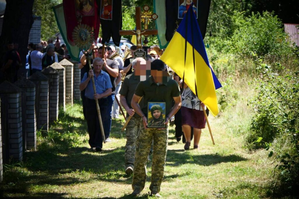 Похоронна процесія з українським прапором і портретом