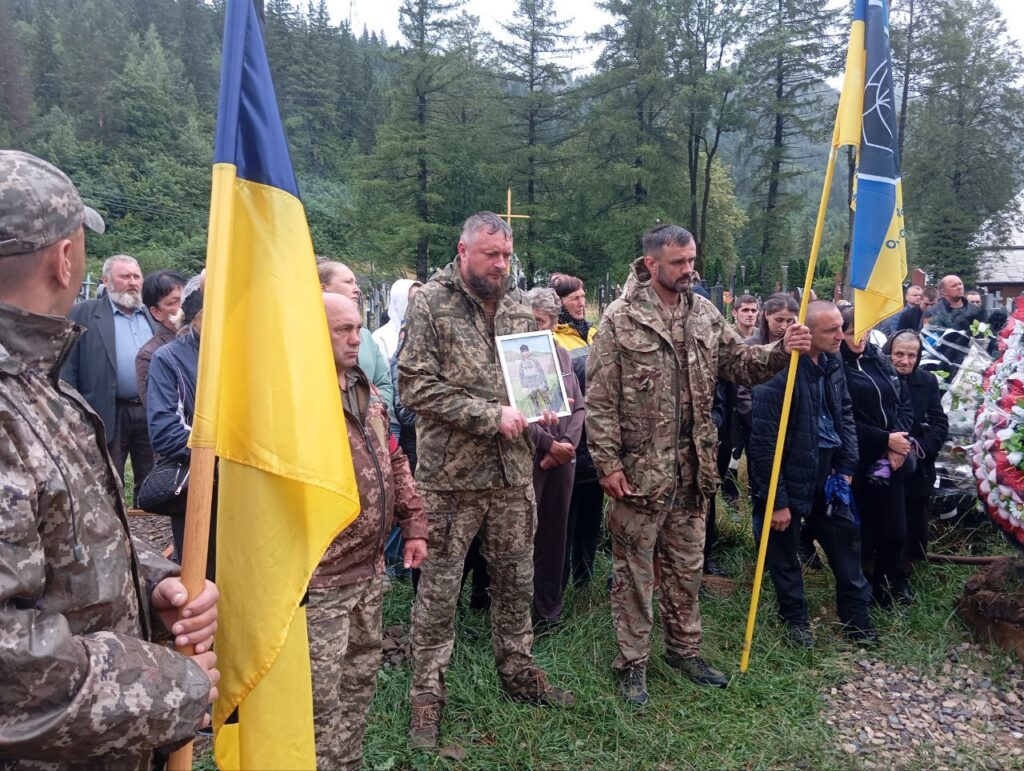 Люди з українським прапором на природі
