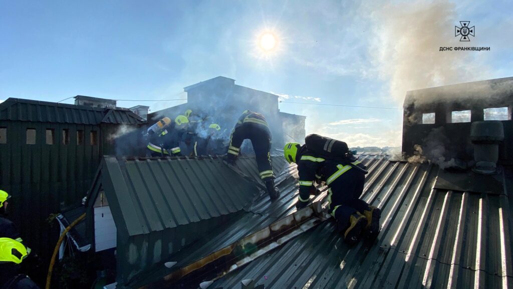 Пожежники на даху під час гасіння вогню.