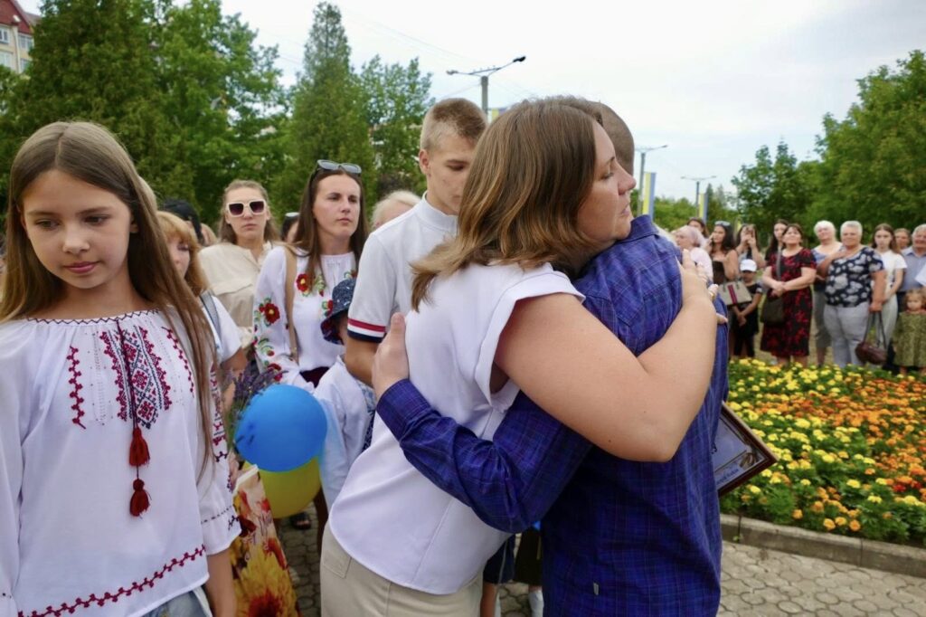 Люди у вишиванках обіймаються на святі.