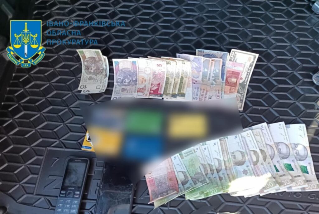 Гроші різних валют на чорному фоні.