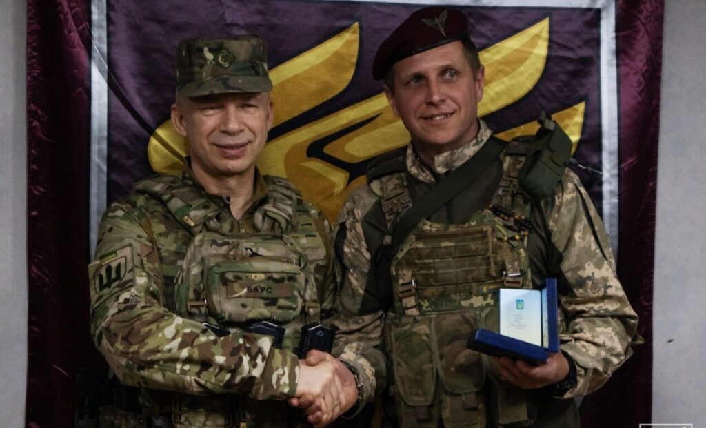 Два військові на церемонії нагородження, рукостискання.