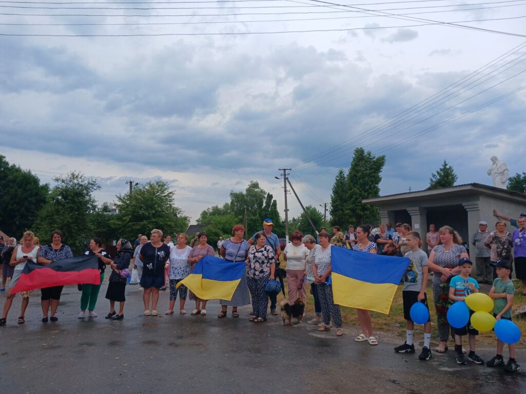 Група людей з українськими прапорами на заході