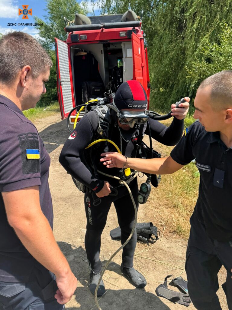 Рятувальники готуються до занурення біля червоного авто