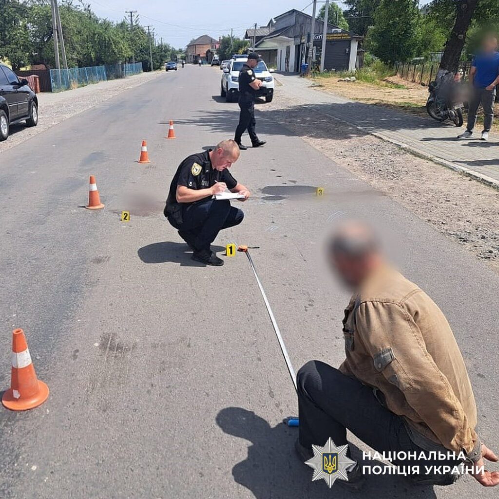 Поліція розслідує ДТП на вулиці, слідчий записує.