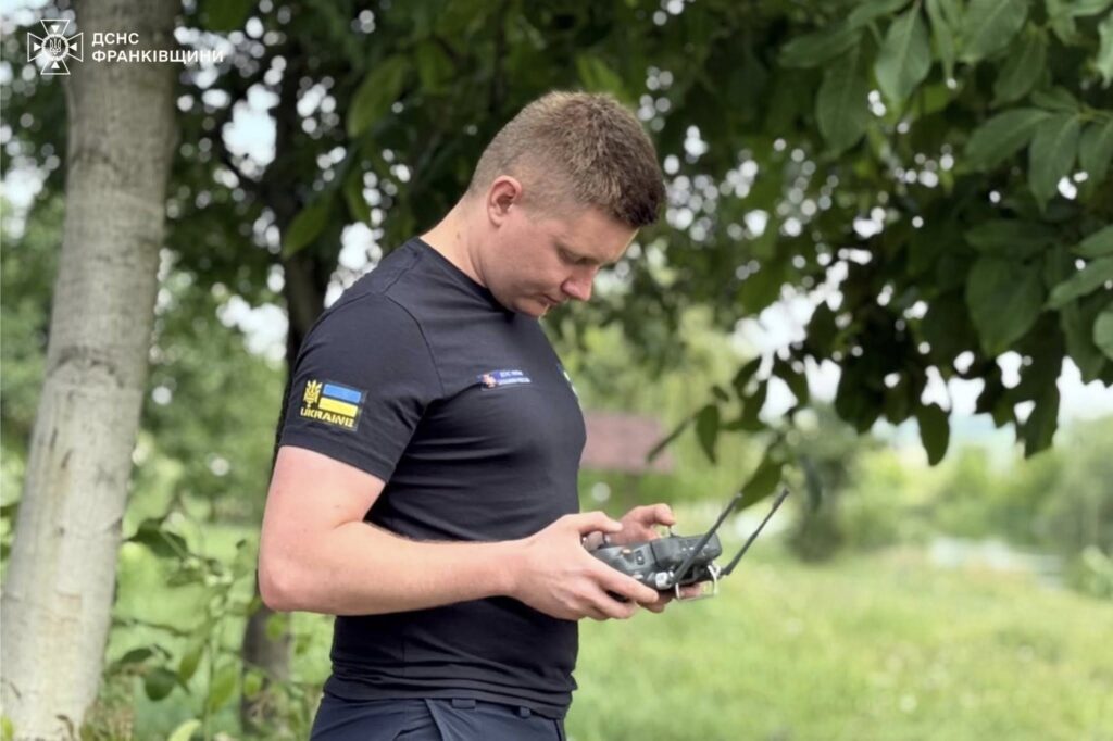 Чоловік керує дроном на природі