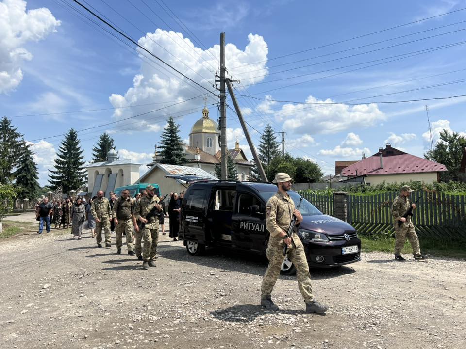Військові охороняють похоронну процесію в селі.