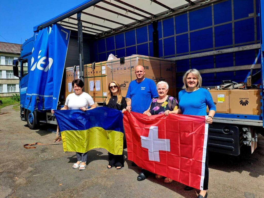 Гуманітарна допомога: люди з прапорами України, Швейцарії