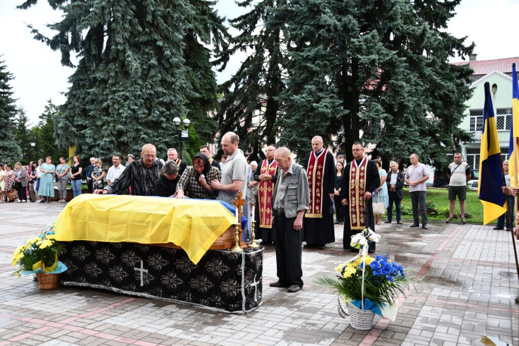 Люди на церемонії прощання з померлим героєм.