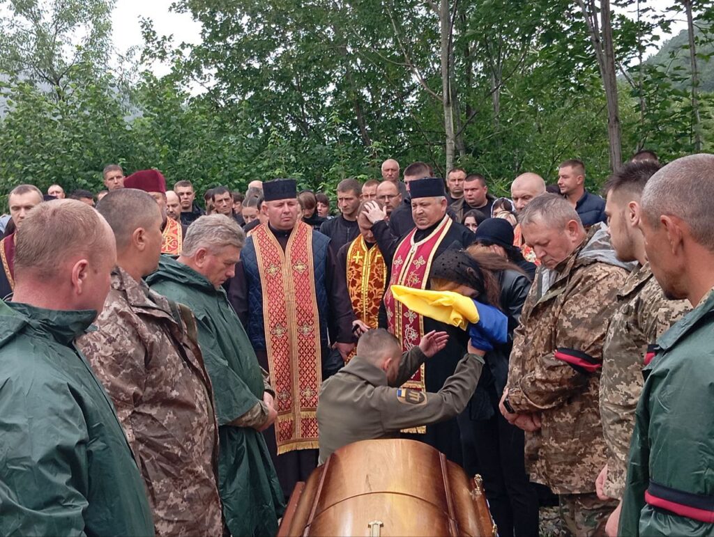 Похоронна церемонія з військовими та священиками.