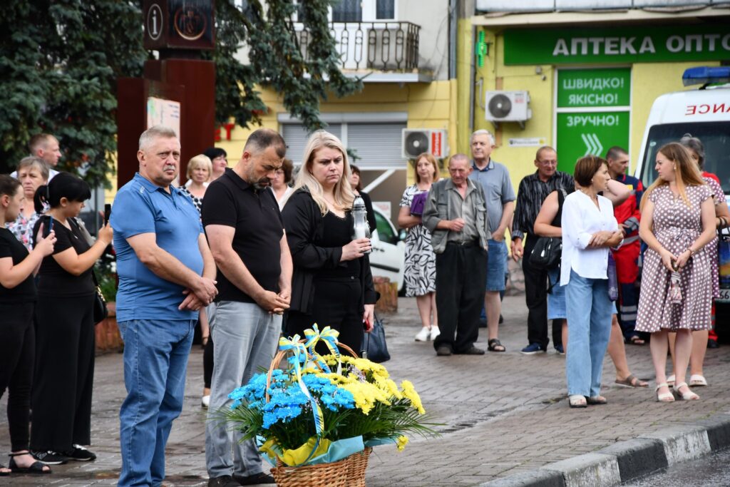Люди на вулиці, вшанування пам'яті з квітами.